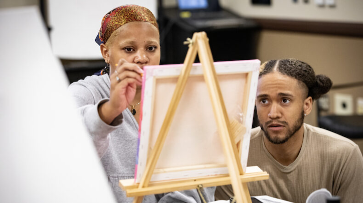 Young folk painting at a venue.