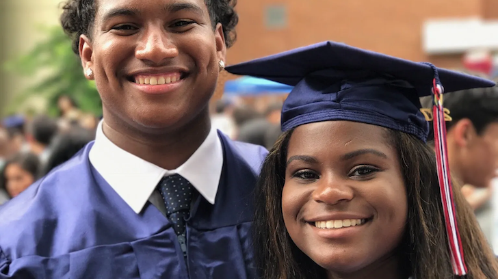 a young male and female at their graduation smiling.